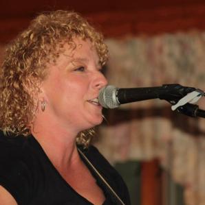 musician, kim buckley singing into a microphone