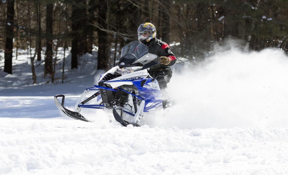 A snowmobile riding fast