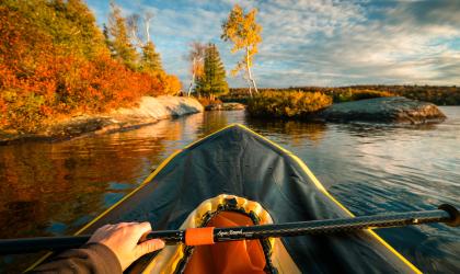 A first person view of paddling a pack raft during sunset.