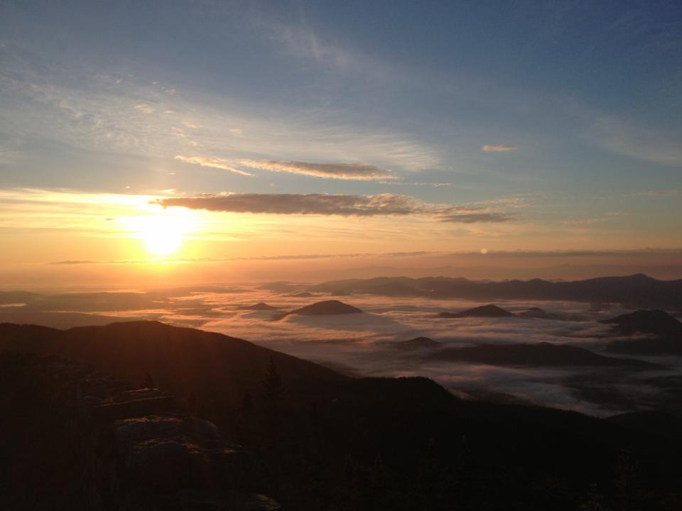 Sunrise with low valley fog from the summit of a mountain