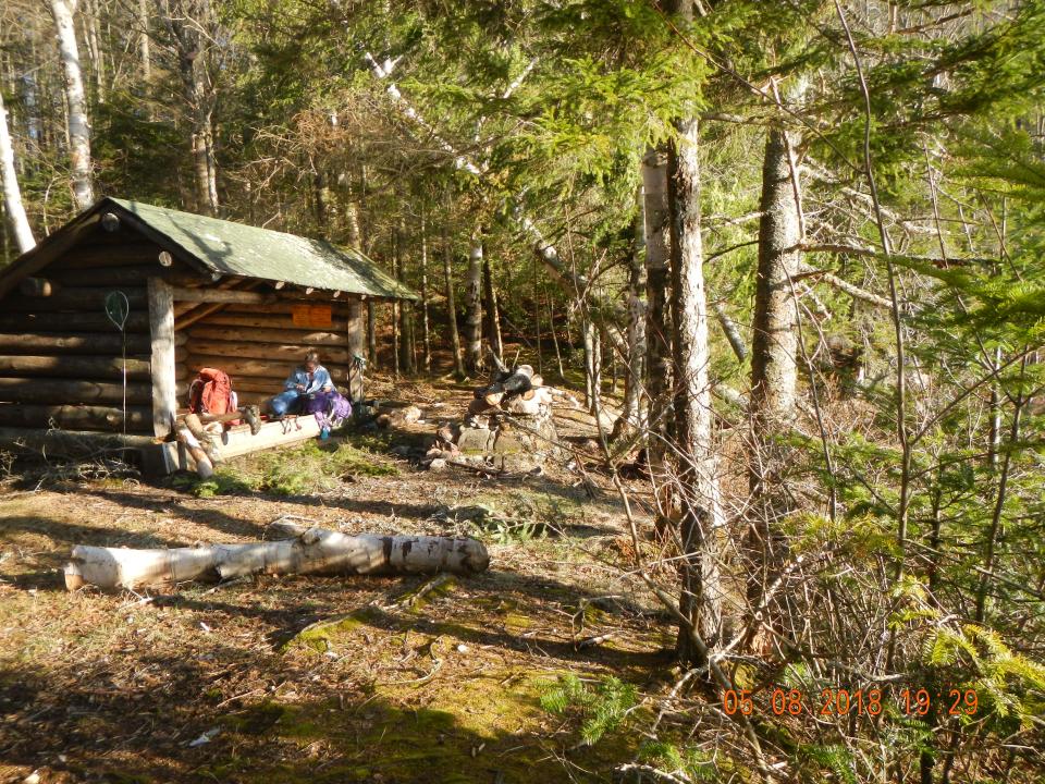 Two hikers enjoy the sun at a lean-to on the Northville-Placid Trail