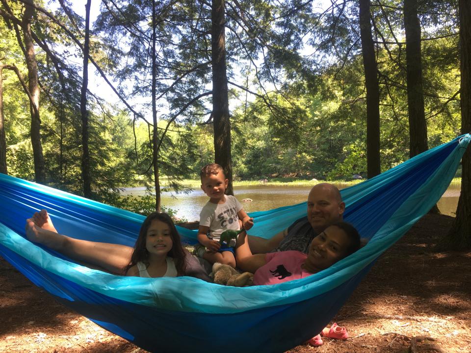 A father and his three daughters pose together in a hammock at Lewey Lake Campground
