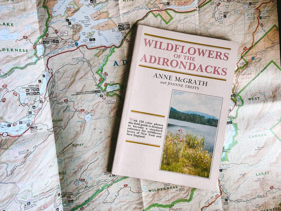 A wildflower ID guide book sitting on a map of Hamilton County