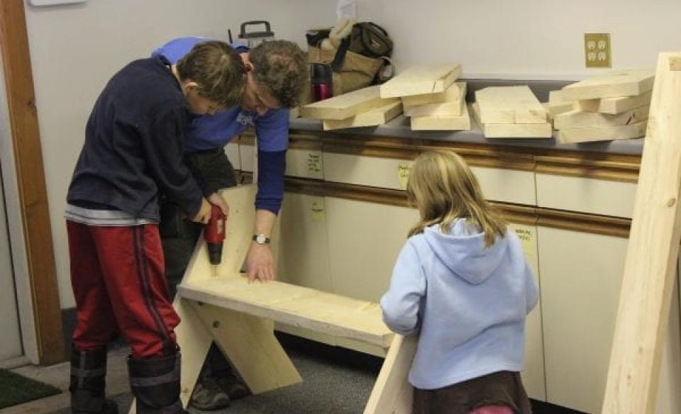Leopold bench being built by father, son, and daughter.