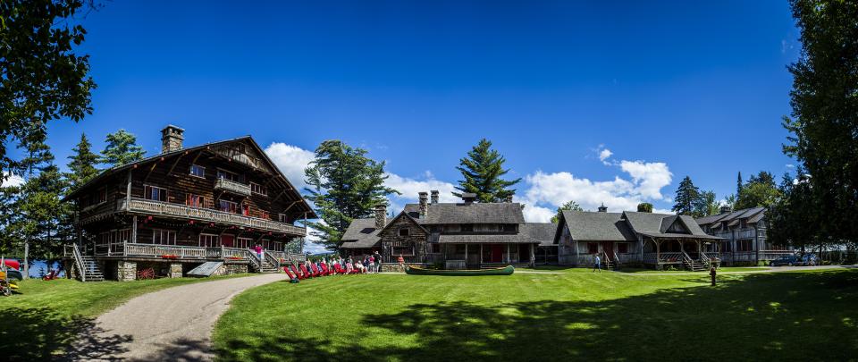 A wide-angle view of an Adirondack Great Camp compound on a sunny day.