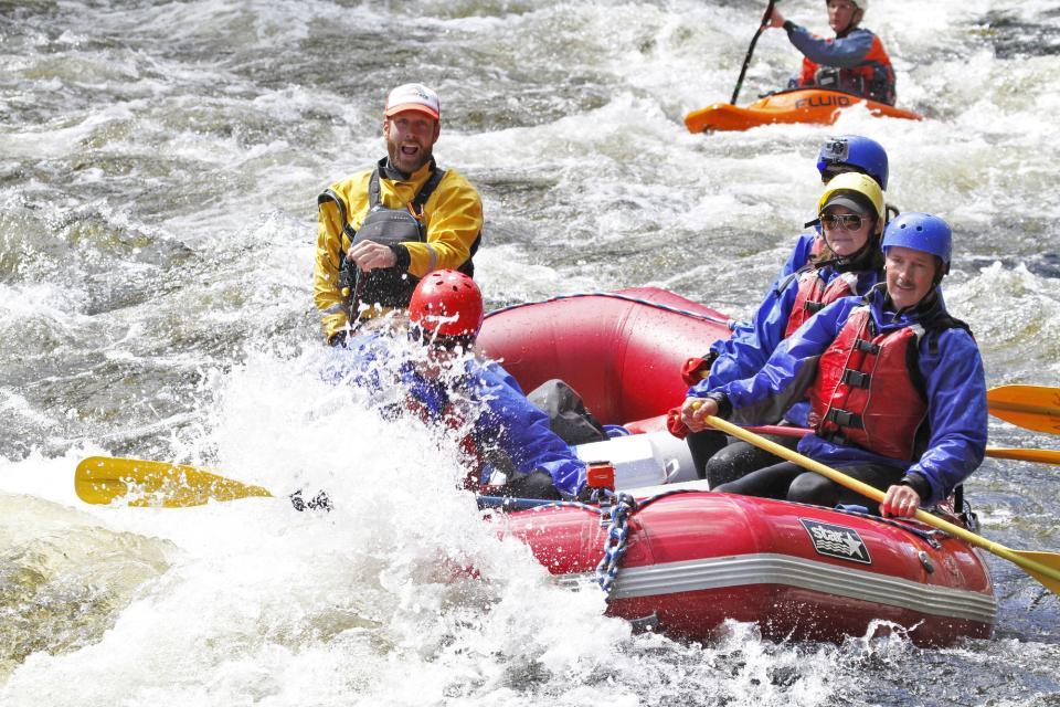 A group paddles in a rafting boat down the Hudson River.