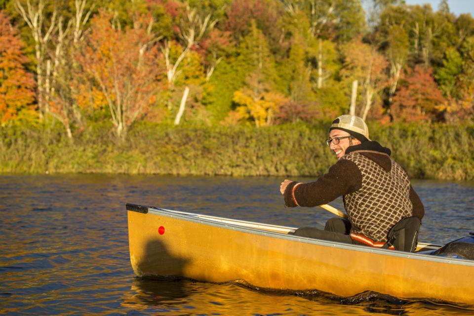 A person rowing at canoe during fall