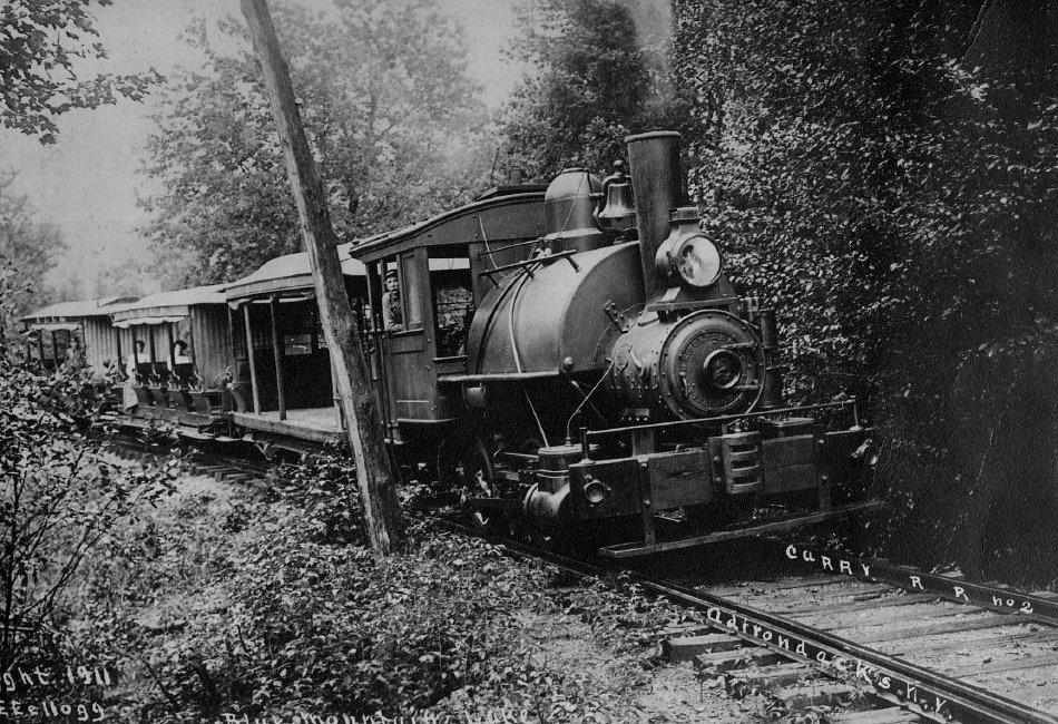 Adirondack Museum Collection. Photo description: Marion River Carry Train, 1911,;Rassie Scarrit at the throttle. 1911 - Kellogg, E.E. photo