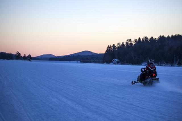 Snowmobiling in Long Lake at sunset.