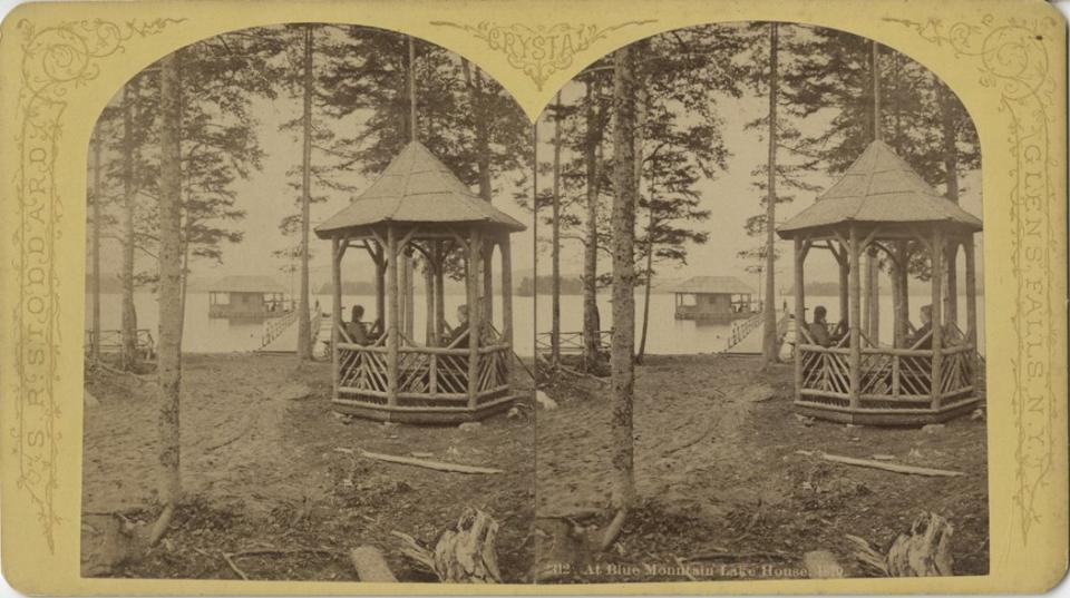Stereoview of women sitting in a pavilion at the Blue Mountain Lake House, looking out towards the lake and the boathouse, Catalog Number 1975.020.0622