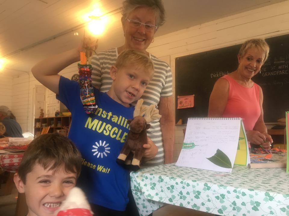 Boys and their grandmothers show off their art projects.
