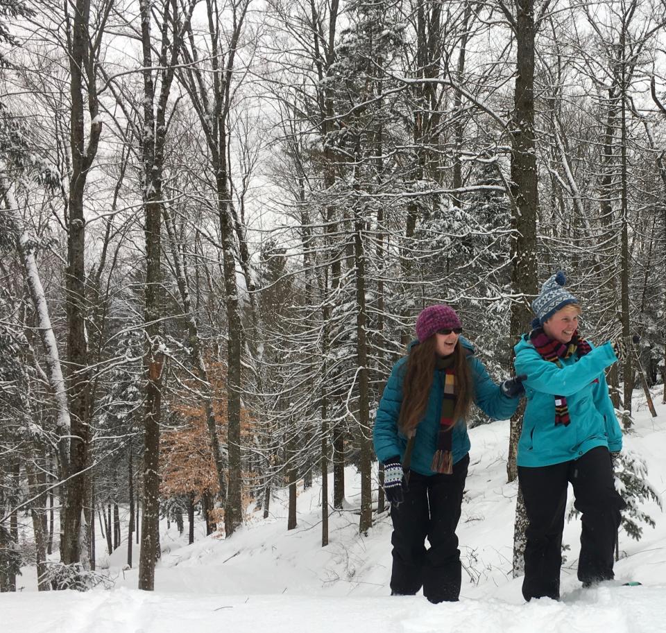 Two women snowshoeing on a trail