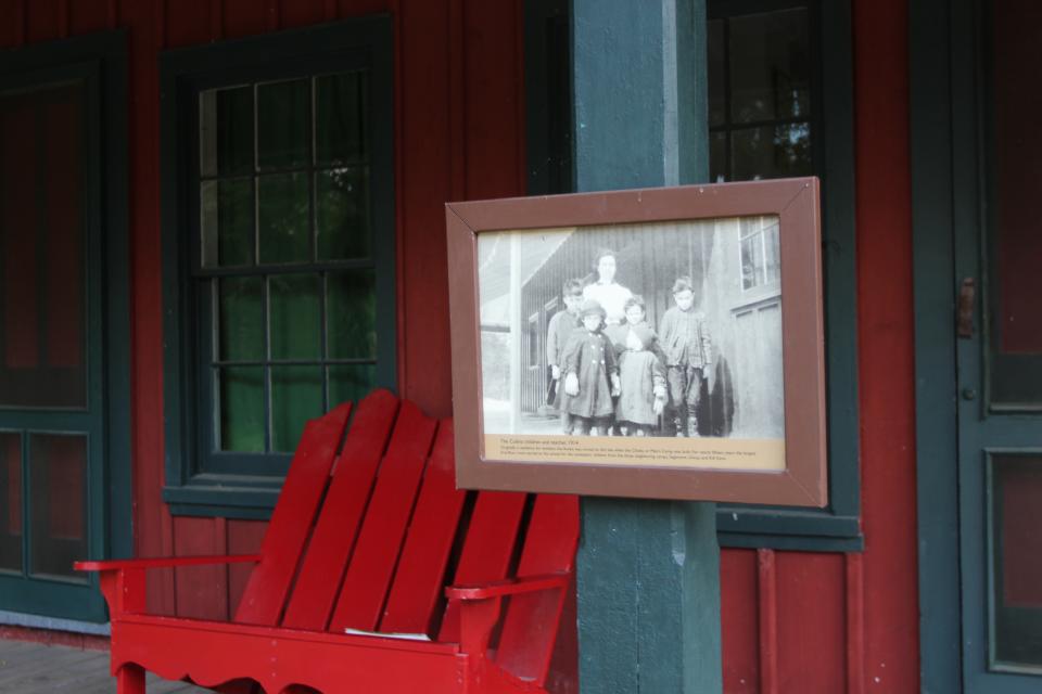 The porch of Sagamore's schoolhouse, with photo of children and their teacher at the school.