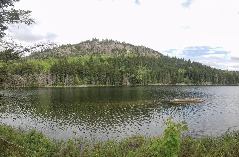 The rocky cliffs above Long Pond loom over the water.