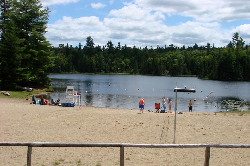 Beach-goers lounge in the sand at Indian Lake Beach
