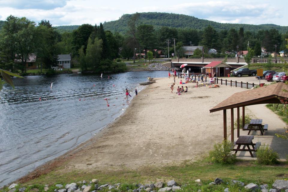 Visitors relax in the sand on the beach of Lake Algonquin