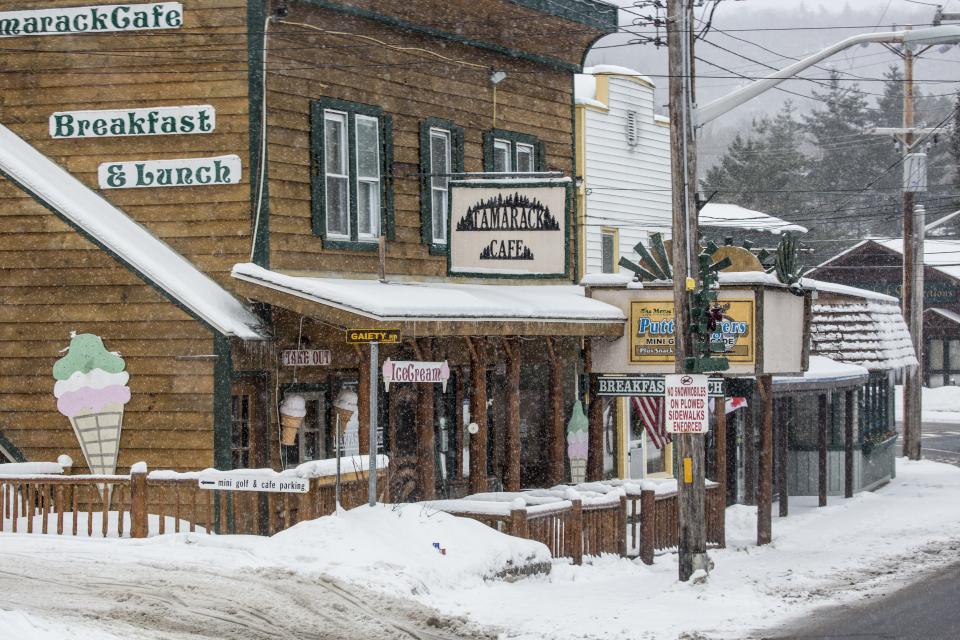 A brown building with a cafe during a snowy day