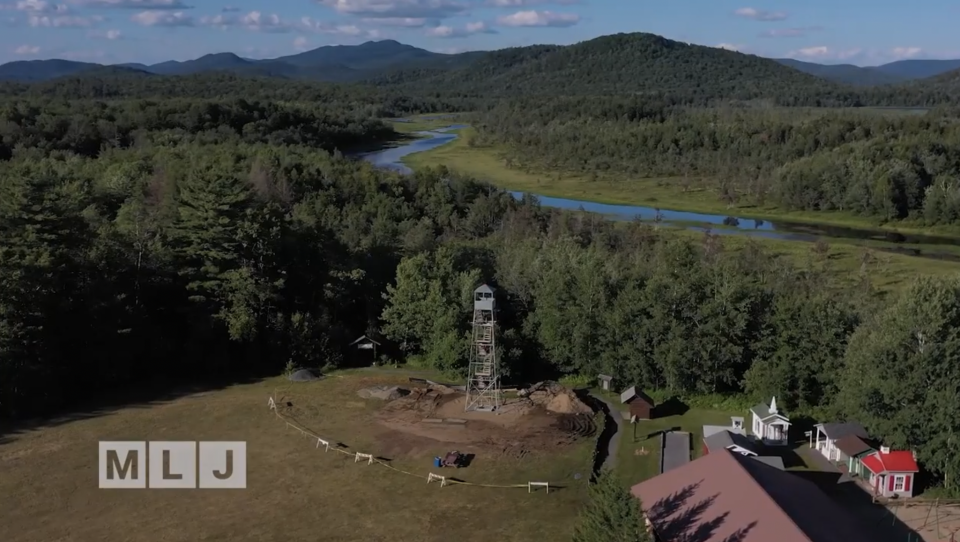 A drone image of the new fire tower in a park with a river and a mountain in the background.