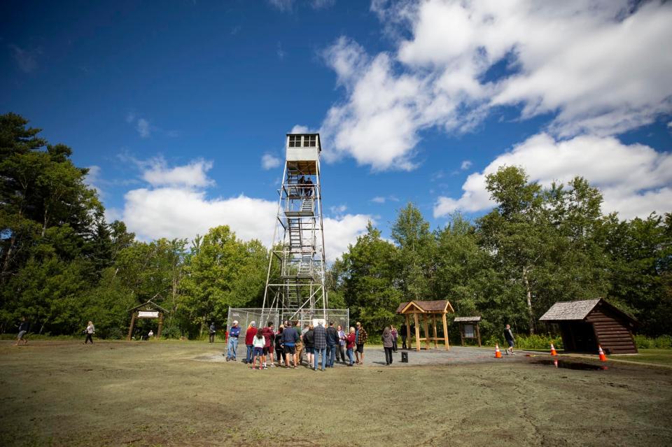 A group stands below the recently opened steel fire tower.