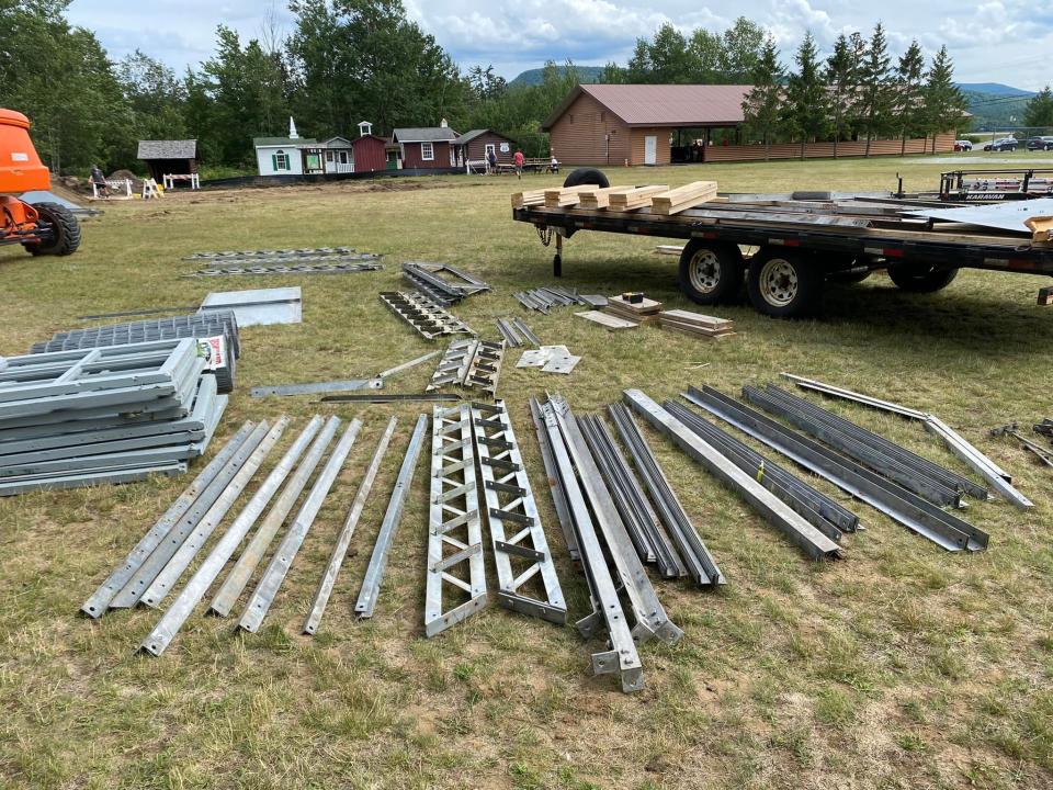Dozens of metal pieces of the Makomis fire tower in the grass