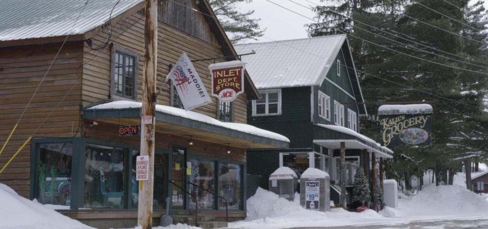 A street view of Inlet, focused on two store fronts in the snow.
