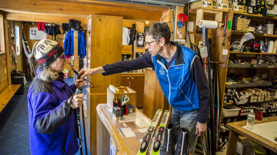 a man helps a woman select ski gear.