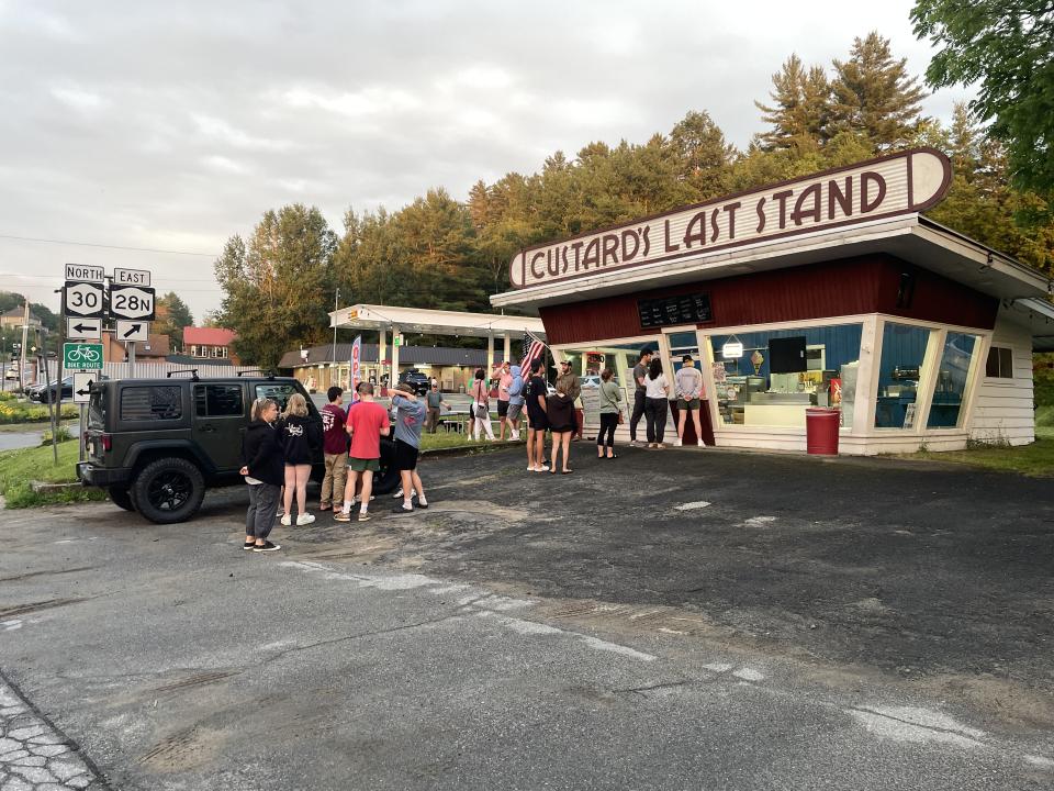 An ice cream stand with people in line