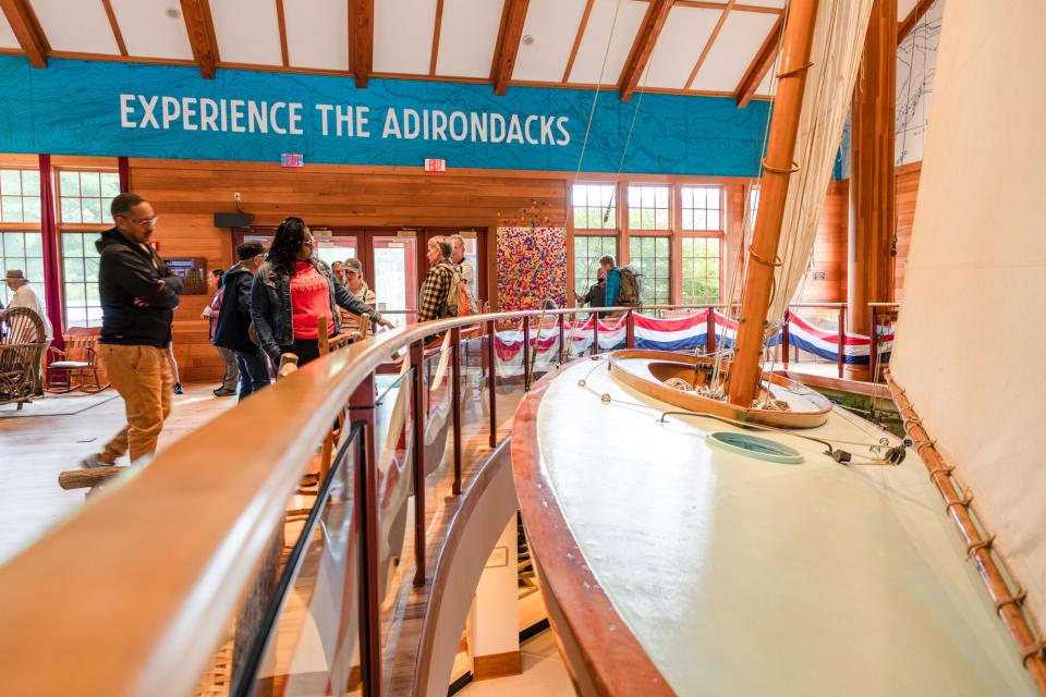 people visit the entrance room of the Adirondack experience.