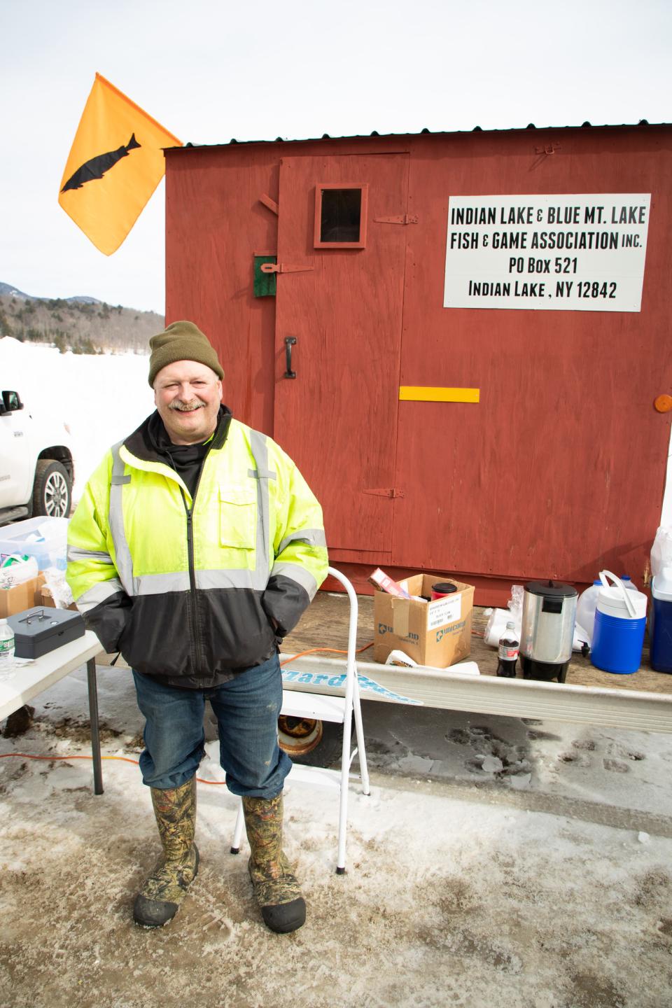 A man smiles at a weigh station during an ice fishing derby.